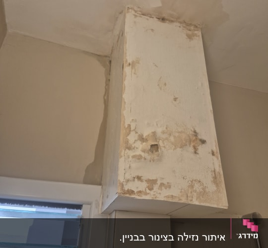 נזקי רטיבות בתקרה ובקיר ליד חלון
